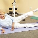 Senior doing pilates leg lifts for hip replacement exercise